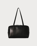 LONDONKELLY The Row Astra black lambskin leather bowling bag with dual zipper closure and elongated handles.